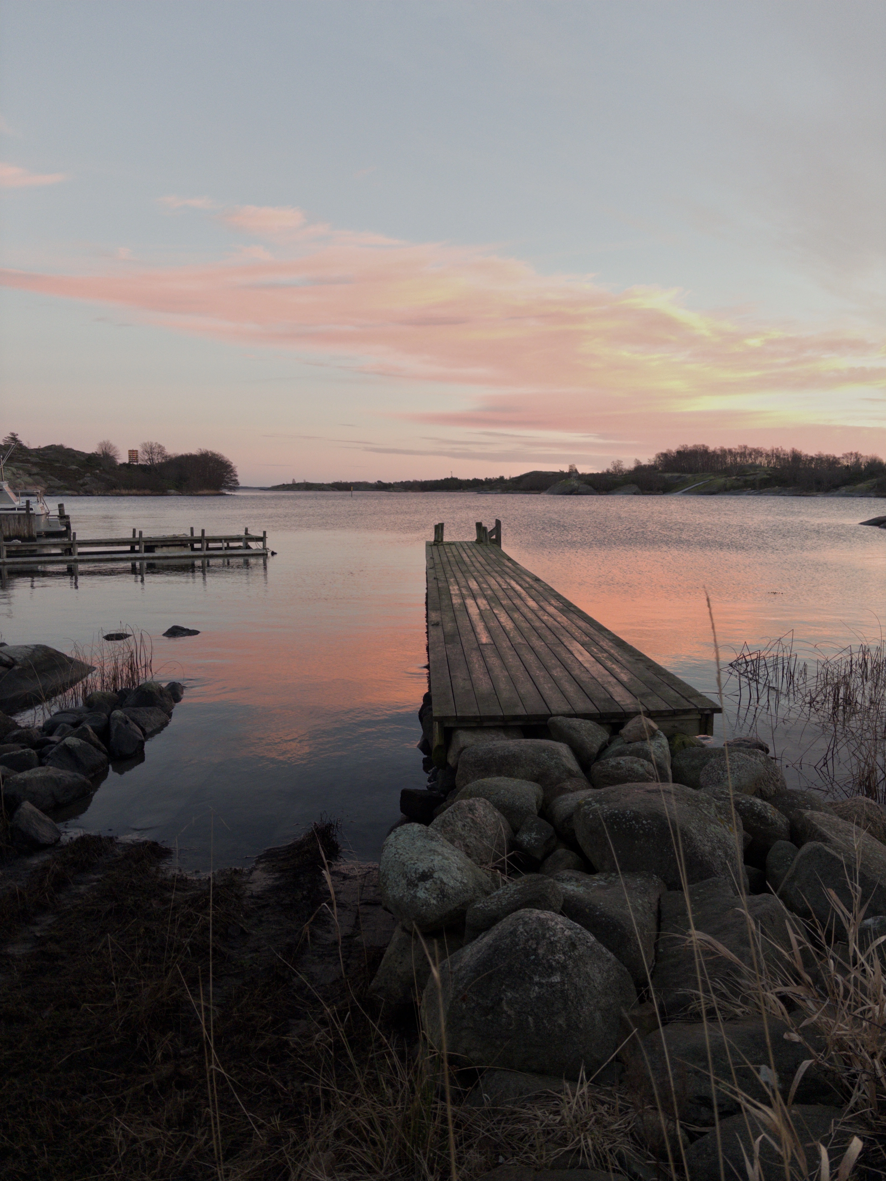 Sunset reflected on the water with a dock extending out into the sea