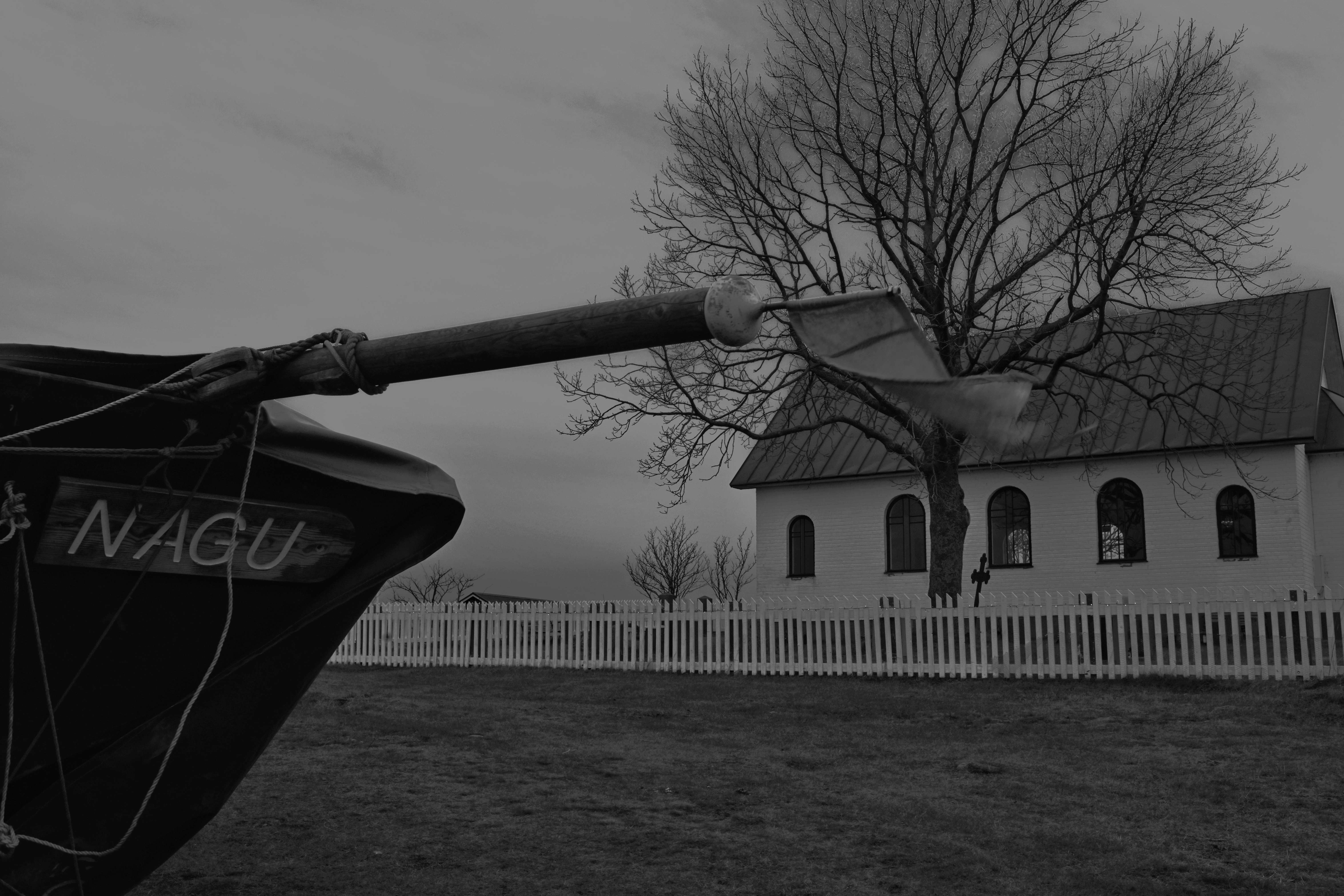 A boat on land with a church in the background