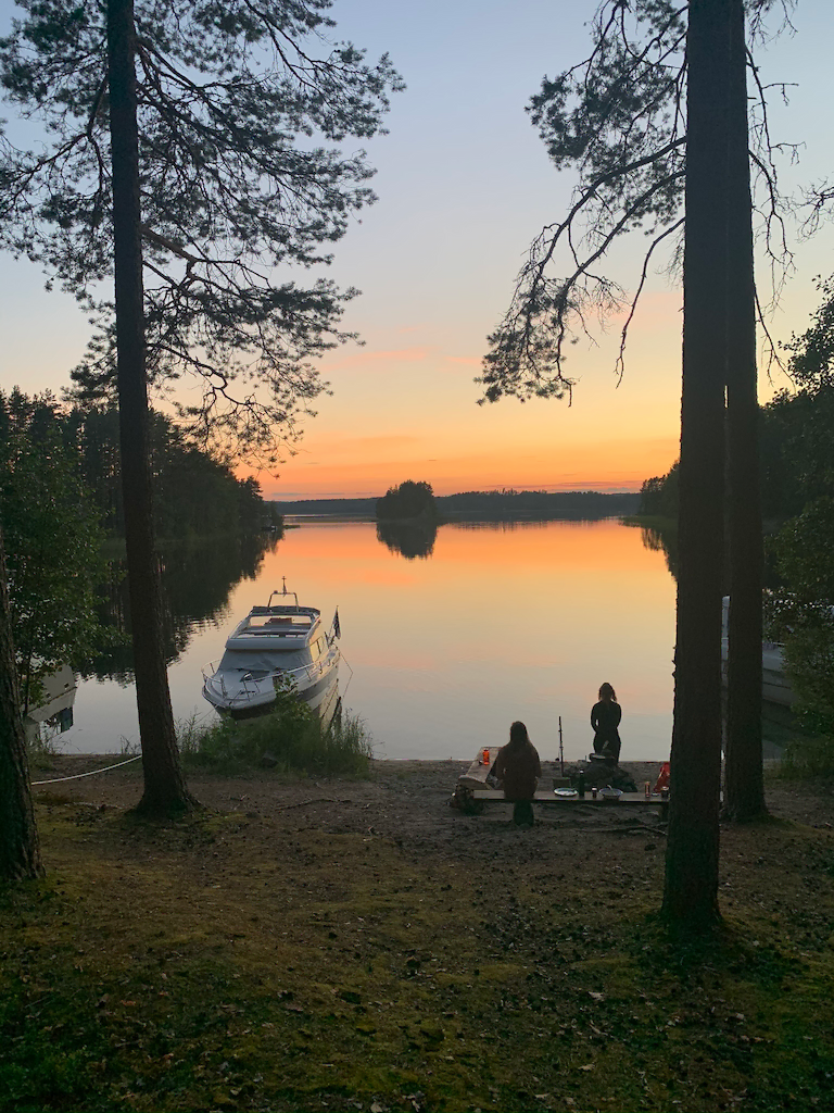 Sunset over lake Saimaa, boat and people in the foreground