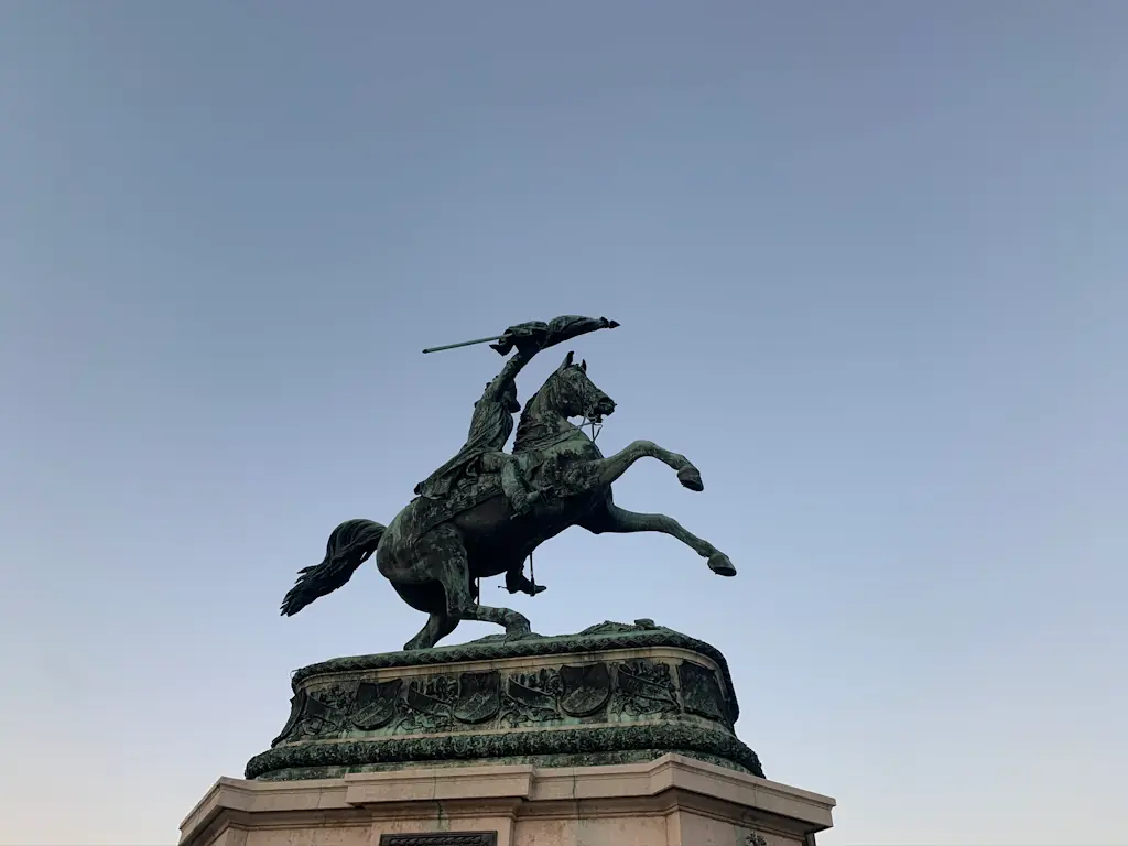Statue of a man on a horse with a flag in his hands. The horse is reared up on its hind legs.