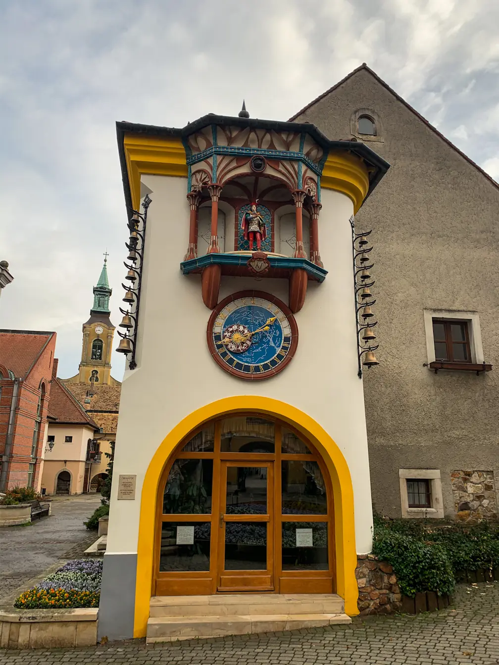 An old tower with an astrological clock. There is a figure of a man with a fancy costume above the clock.
