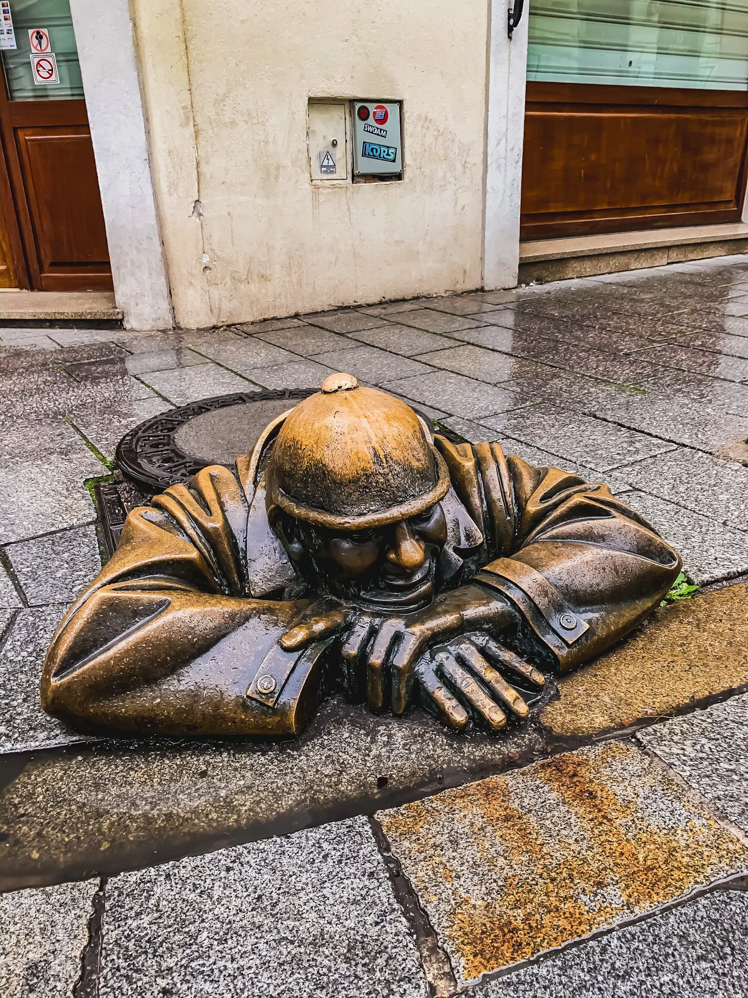 Man at Work statue. A bronze cast statue of a man peering out of a manhole.
